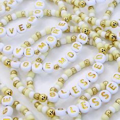 several white and gold beads with words on them