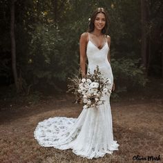 a woman in a wedding dress holding a bridal bouquet and posing for a photo