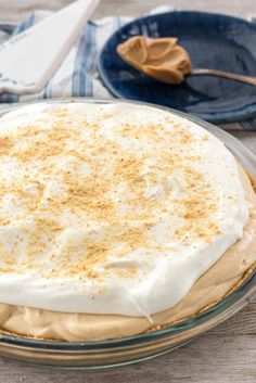 a cake with white frosting and cinnamon sprinkles in a glass pie dish