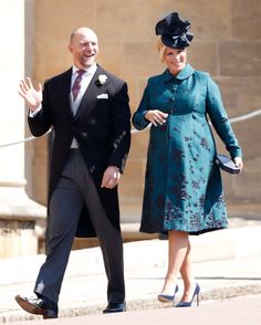 the man and woman are walking down the street together, dressed in suits and hats