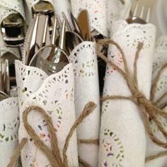 an image of a table setting with utensils and napkins tied up in twine