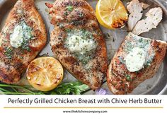 grilled chicken breast with chive herb butter and lemon wedges on a platter