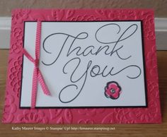 a pink and white thank you card with a ribbon on the front, and a flower in the middle