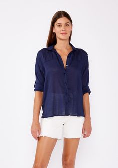 [Color: Navy] A brunette woman wearing a sheer blue shirt with a collared neckline Summer Shirt For Day Out With 3/4 Sleeves, Chic Shirt With Relaxed Fit And 3/4 Sleeve, Relaxed Fit Blouse With Button Cuffs And 3/4 Sleeves, Chic Relaxed Fit Shirt With 3/4 Sleeves, Summer Half-sleeve Blouse With Roll-up Sleeves, Summer Tops With Roll-up 3/4 Sleeves, Classic Summer Shirt With Back Button Closure, Summer Blouse With 3/4 Roll-up Sleeves, Casual 3/4 Sleeve Shirt For Day Out