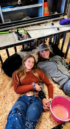 two people laying on the ground next to a table