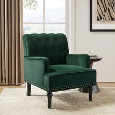 a green chair sitting on top of a rug in front of a window with curtains