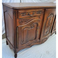 an old wooden cabinet with ornate carvings on the doors and drawers is shown in front of a white backdrop