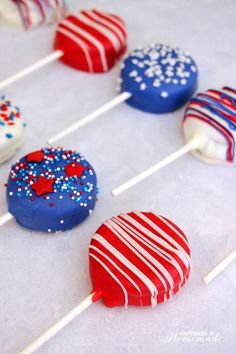 red, white and blue cake pops with sprinkles are arranged on a table