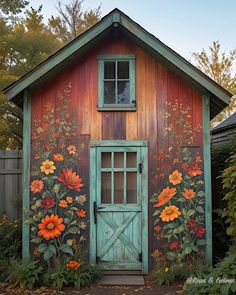 an old barn with flowers painted on the side and door is shown in this photo