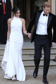 prince harry and his bride are holding hands as they walk down the steps at their wedding