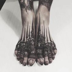 a person's feet with tattoos on them and their hands in the shape of towers