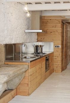 an empty kitchen with wooden walls and flooring