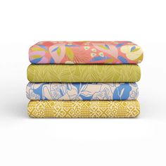 four colorful sheets stacked on top of each other in different colors and patterns, with one folded