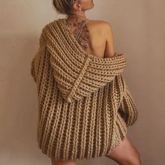 a woman wearing a sweater made out of knitted yarn with tattoos on her back