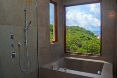 a bathroom with a large window overlooking the ocean