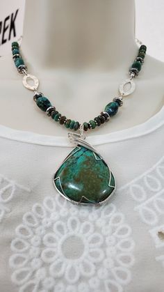 This Turquoise necklace features a beautiful natural Arizona Kingman turquoise stone wire-wrapped pendant. I cut & shaped this pendant stone from natural virgin rock and polished it to a high luster 50,000th diamond polish finish.  I then wire-wrapped the pendant stone using 6 bands of 24 gauge sterling silver wire, finishing of the wrap with my signature "sweep top bail design". This stone has a deep shine with a beautiful mixture of blue-greens color shades and a brown matrix. The turquoise pendant stone, wire-wrapped, measures about 2.15 inches long (5.30 centimeters) by 1.45 inches wide (3.60 centimeters).  The Turquoise pendant is the central focus piece of this turquoise necklace.  The necklace is comprised of various sized natural turquoise 6mm roundels & 11mm oval stones along with Turquoise Pendant Necklace, Sacred Stones, Bali Silver, Deep Meditation, Turquoise Crystal, Third Eye Chakra, Kingman Turquoise, Turquoise Pendant, Wrapped Pendant