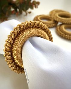 napkins with gold rings on them sitting on a table