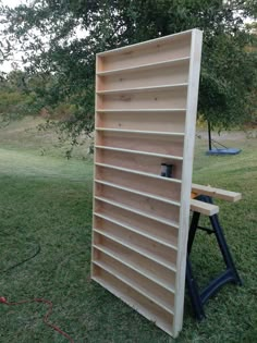 a wooden shelf sitting on top of a green field