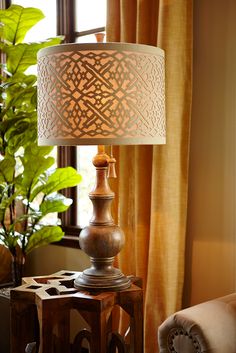 a lamp that is on top of a wooden table next to a potted plant