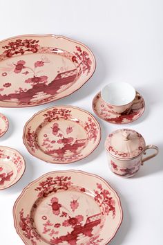 an assortment of red and white china dishes