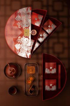 an overhead view of a red table with plates and cups on it, including tea