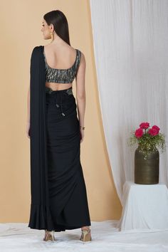 Ooze style and class in this ready to wear saree in a stunning black hue. With a contrasting blouse and belt, this saree is a classic pick for cocktail parties, soirées and weddings!Style Ready to Wear Saree Embellished Belt Contrasting Blouse Classic Black hue Armani silk fabric Specifications Model height - 5'9" Model wearing - S Festive Black Pre-draped Saree With Self Design, Elegant Black Pre-draped Saree With Zari Work, Formal Party Wear Choli, Elegant Party Pre-draped Saree With Zari Work, Elegant Party Sets With Side Open Design, Festive Black Pre-draped Saree With Cutdana, Formal Fitted Pre-draped Saree With Cutdana, Elegant Unstitched Side Open Choli, Elegant Unstitched Side-open Choli