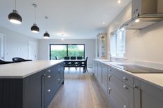 a kitchen with white counter tops and gray cabinets