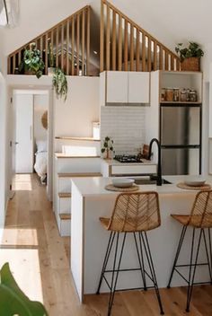 two stools are in front of the kitchen counter and bar area with an open floor plan