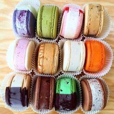 there are many different colored macaroons in the box