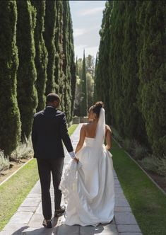 the bride and groom are walking down the path