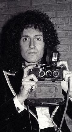 a man holding up an old camera in front of his face