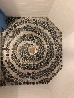 a white toilet sitting in a bathroom next to a tiled wall and floor with circles on it