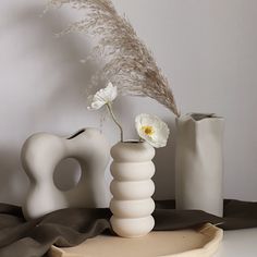 there is a vase with flowers in it and two other items next to the vase