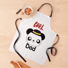 an apron with the words cool dad printed on it and a bowl of eggs next to it