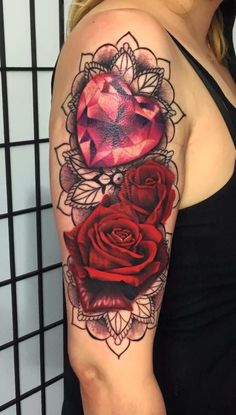 a woman's arm with two roses on it and a diamond in the middle