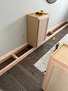 an unfinished kitchen cabinet is being built in the middle of a room with wood flooring