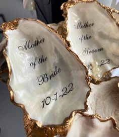 three mother of the bride seashells with names on them sitting next to each other