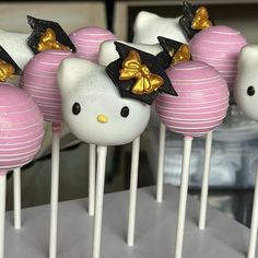 hello kitty cake pops with gold bows on them