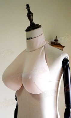 a mannequin wearing a white top with black straps and an ironing board