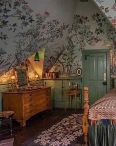 a bedroom with floral wallpaper and wooden furniture in the corner, along with a green door