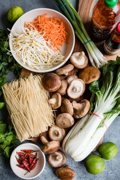 the ingredients are laid out on the table to be used in this recipe, including mushrooms, noodles, and vegetables