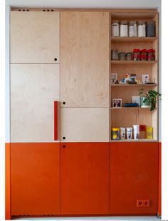 an orange cabinet with shelves and jars on it's sides, in front of a white wall