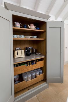 an open cupboard with coffee cups and other items