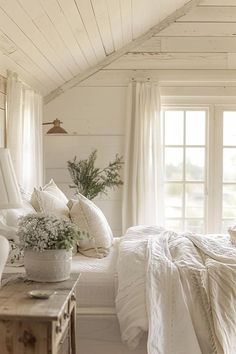 a bedroom with white bedding and pillows