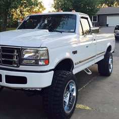 a white pick up truck parked in a driveway