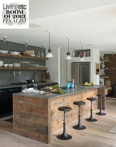 a kitchen with an island made out of wooden pallets and stools next to it