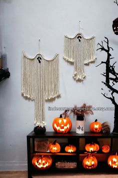 halloween decorations are displayed in front of a white wall with fringe curtains and pumpkins