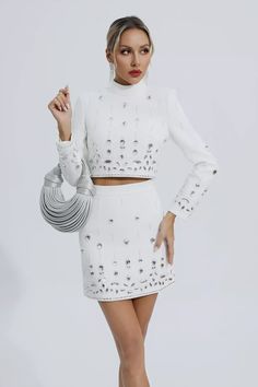 Cecelia White Crystal Embellished Set offers a modern and stylish look. This trendy set features a mid-collar cropped blazer with crystal diamond embellishments and a mini skirt. Elegant in design and exquisite in tailoring, it is suitable for most important occasions. Pair with high heels or boots and a handbag of the same color for a chic look.  Top Length: Approx 42cm Skirt Length: Approx 41cm Materials: Polyester Gentle Dry Clean Only  The model is 5 ft 7 and wears size S  Color may vary due Glitter Wedding Dress, Skirt Elegant, High Neck Crop Top, Bandage Dress Bodycon, Top Skirt Set, Crystal Diamond, Cropped Blazer, Handmade Dresses, White Crystal