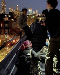 three people standing on top of a building at night