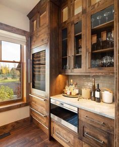 an image of a kitchen setting with wooden cabinets and wine glasses on the counter top